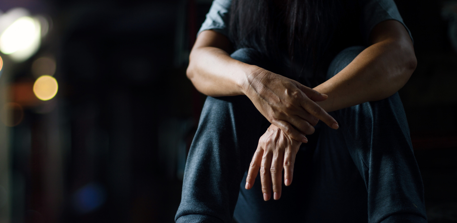 depressed person sitting down. Is depression genetic?