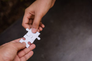 Hands with puzzle pieces to build trust in relationships